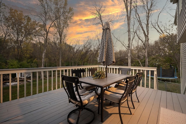 deck at dusk featuring a trampoline