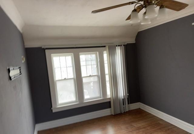 empty room with ceiling fan, hardwood / wood-style floors, and lofted ceiling