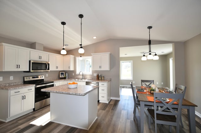 kitchen featuring white cabinets, a kitchen island, decorative light fixtures, stainless steel appliances, and dark hardwood / wood-style floors