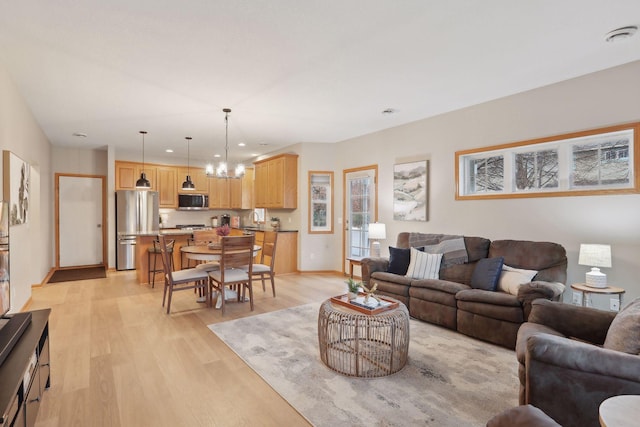 living room with light hardwood / wood-style floors and a chandelier