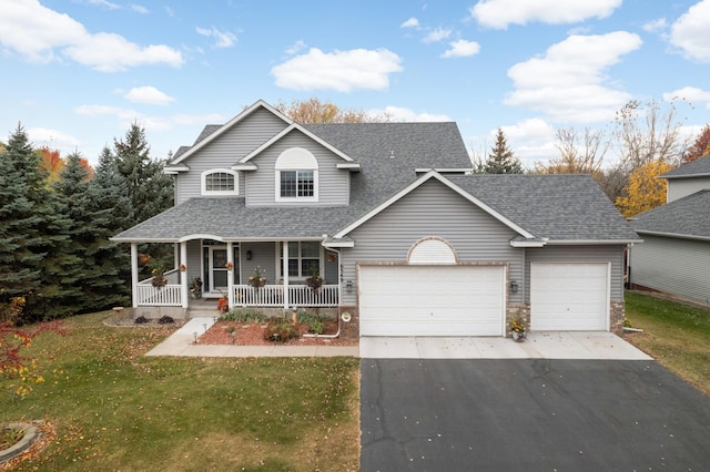 view of front of house featuring a front lawn, covered porch, and a garage