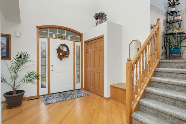 entryway with a towering ceiling and hardwood / wood-style flooring