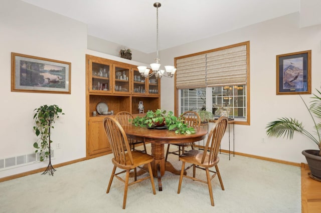 carpeted dining room with a notable chandelier