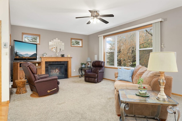 living room with a fireplace, carpet floors, and ceiling fan