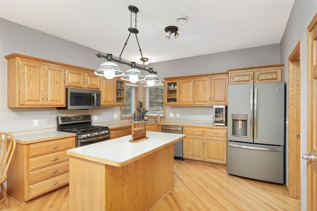 kitchen featuring a center island, light hardwood / wood-style flooring, pendant lighting, and appliances with stainless steel finishes