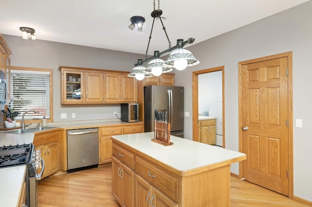 kitchen featuring a kitchen island, sink, stainless steel appliances, and light hardwood / wood-style flooring