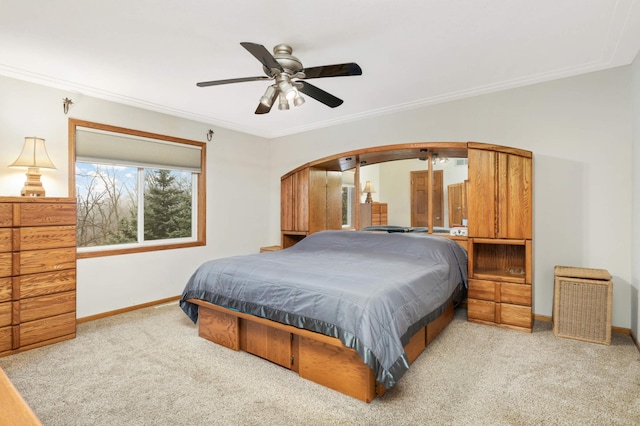 carpeted bedroom featuring ceiling fan and crown molding