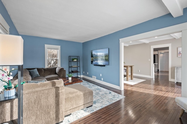 living room with dark wood-type flooring and beamed ceiling