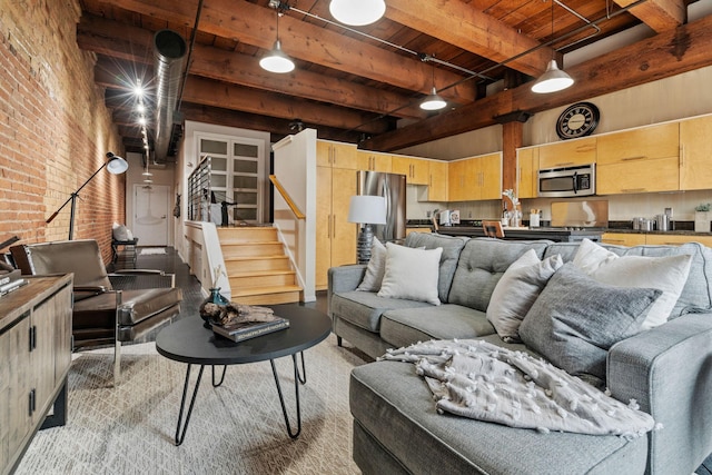 living room with wooden ceiling, beamed ceiling, brick wall, and a high ceiling