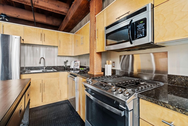 kitchen with dark stone countertops, sink, and appliances with stainless steel finishes