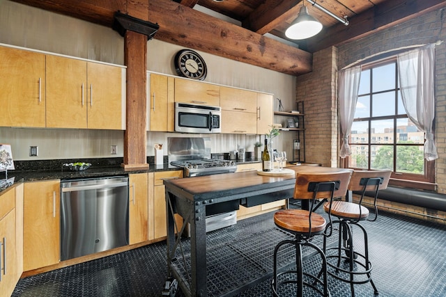 kitchen featuring appliances with stainless steel finishes, light brown cabinetry, brick wall, beam ceiling, and carpet floors