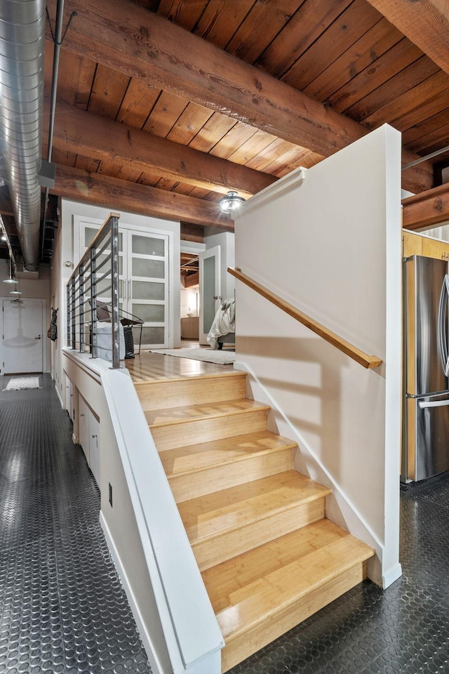 stairs featuring beam ceiling and wooden ceiling