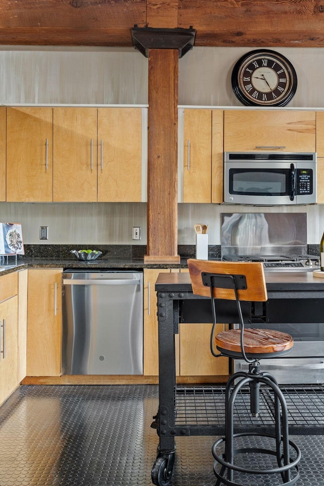 kitchen featuring dark stone counters and stainless steel appliances