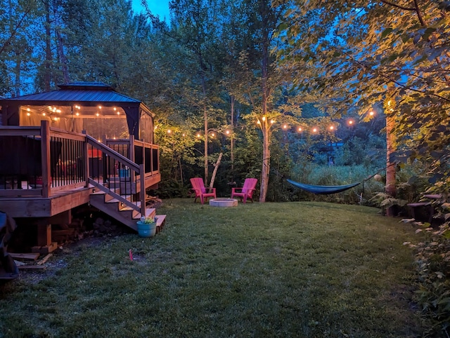 view of yard with a deck and a fire pit