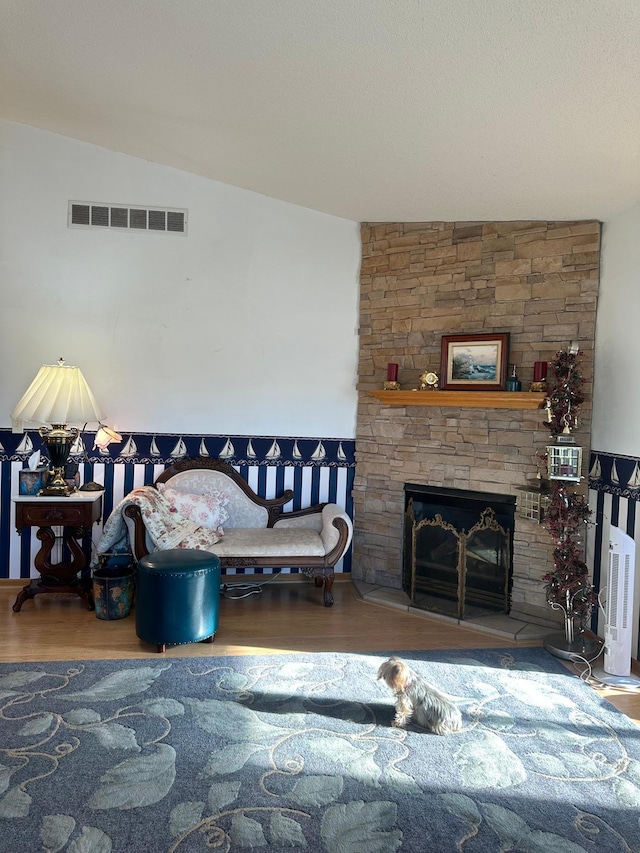 living room featuring wood-type flooring, a fireplace, and vaulted ceiling