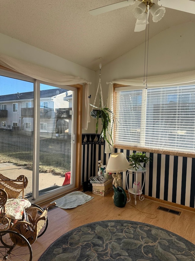 sunroom with ceiling fan and vaulted ceiling