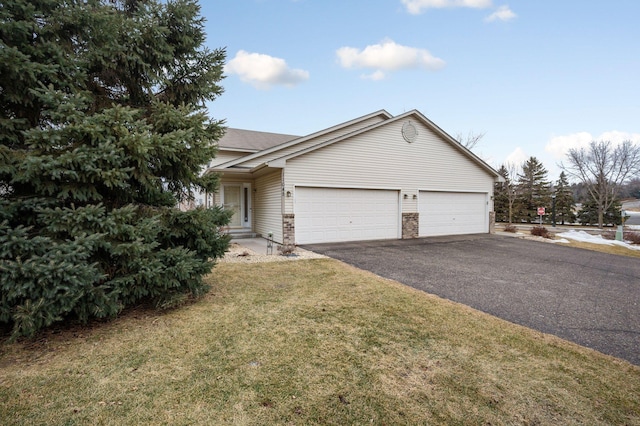 ranch-style house featuring a garage and a front lawn