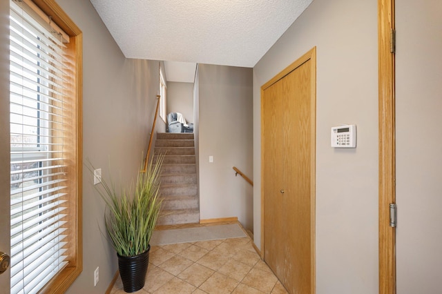 staircase with tile patterned floors and a textured ceiling