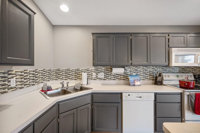 kitchen featuring white appliances, gray cabinetry, and sink