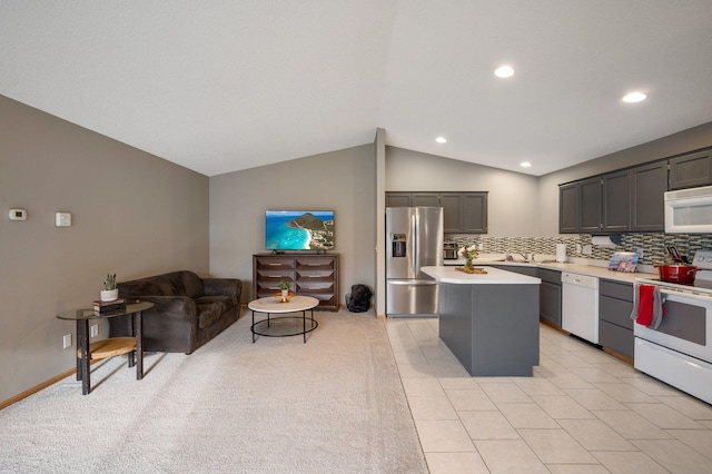 kitchen with backsplash, white appliances, vaulted ceiling, light tile patterned floors, and a center island