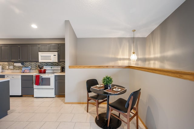 kitchen with white appliances, hanging light fixtures, and backsplash