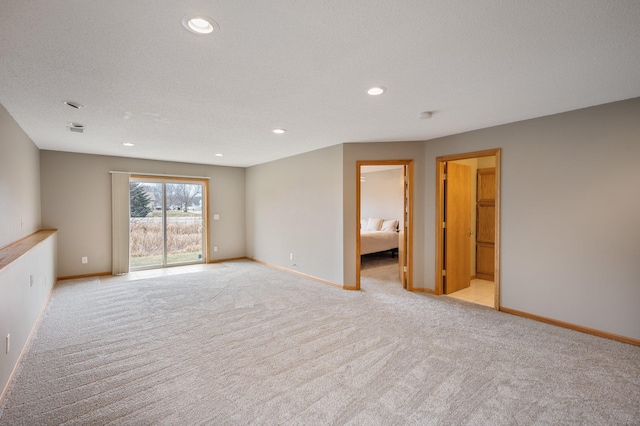 spare room with a textured ceiling and light colored carpet