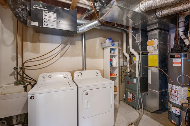 laundry room with heating unit, sink, water heater, light tile patterned floors, and independent washer and dryer