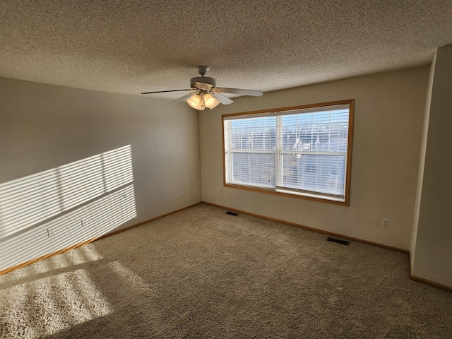 carpeted empty room with ceiling fan and a textured ceiling