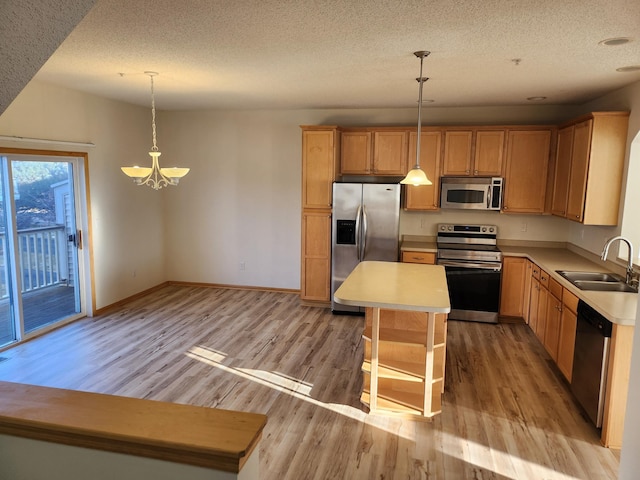 kitchen featuring pendant lighting, a center island, sink, and stainless steel appliances