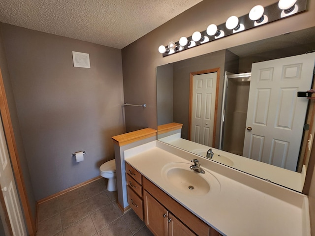 bathroom with tile patterned floors, vanity, a textured ceiling, a shower with door, and toilet