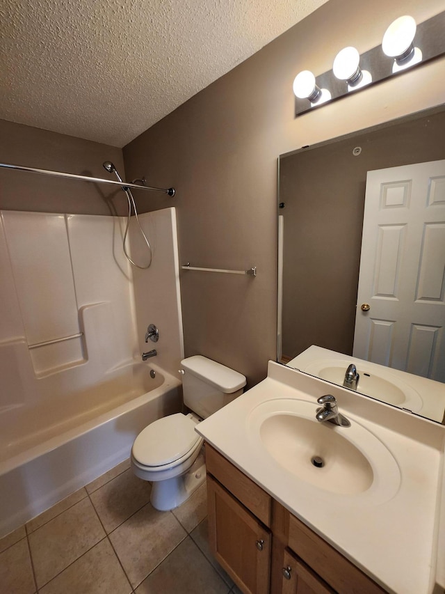 full bathroom featuring washtub / shower combination, tile patterned floors, a textured ceiling, toilet, and vanity