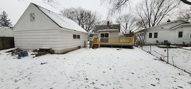 snow covered house with a wooden deck