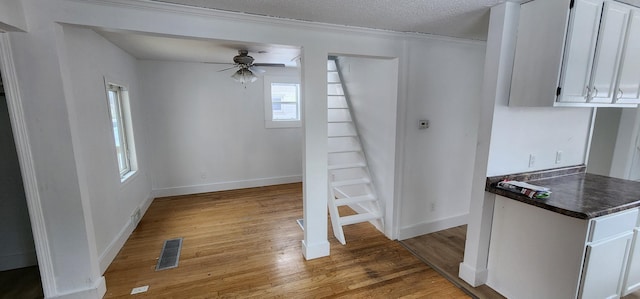 interior space featuring ceiling fan, light hardwood / wood-style floors, and a textured ceiling