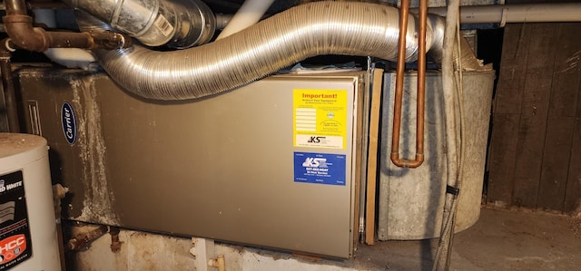 utility room featuring heating unit and water heater