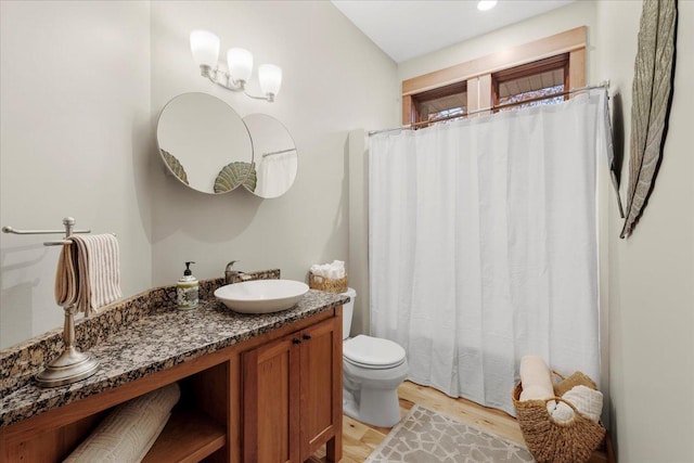 bathroom featuring wood-type flooring, toilet, and vanity