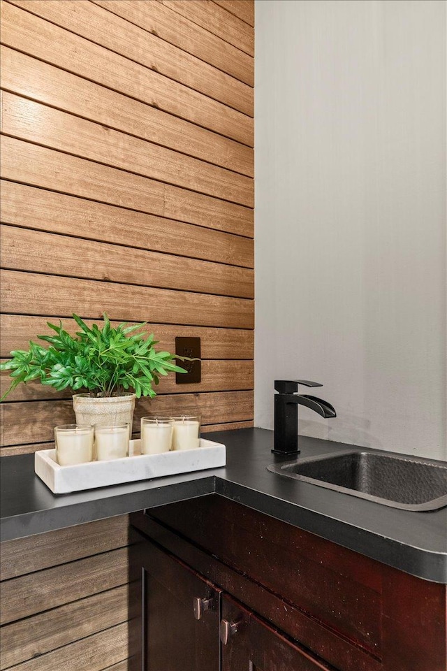 bar with dark brown cabinets and wood walls