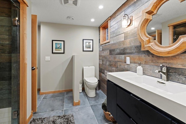 bathroom with vanity, toilet, wood walls, and tile patterned flooring