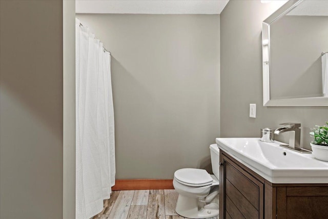 bathroom with vanity, toilet, and wood-type flooring