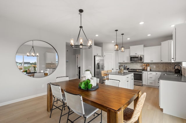 dining room with a chandelier, light hardwood / wood-style flooring, and sink