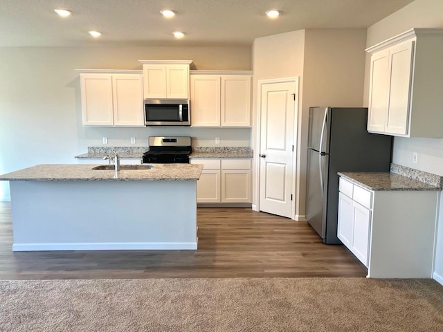 kitchen with an island with sink, sink, white cabinets, and stainless steel appliances