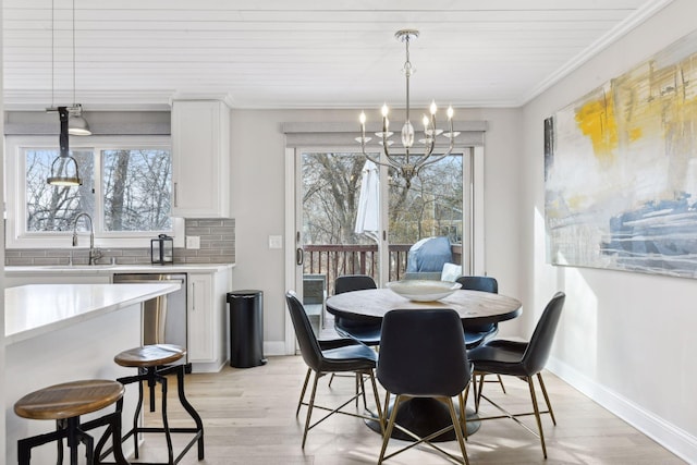 dining space with crown molding, sink, wooden ceiling, a chandelier, and light hardwood / wood-style floors