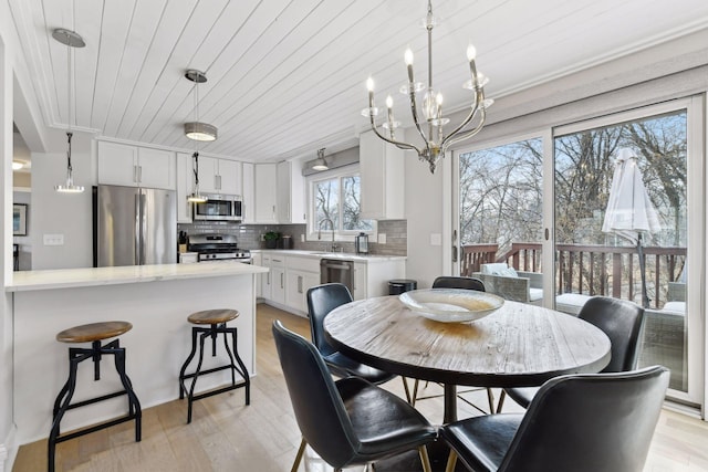 dining area featuring an inviting chandelier, wood ceiling, and light wood-type flooring