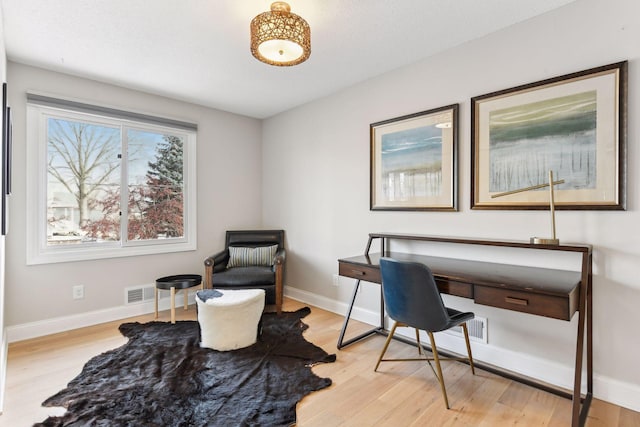 home office with light hardwood / wood-style floors