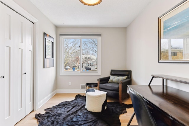 sitting room featuring light hardwood / wood-style floors and a textured ceiling