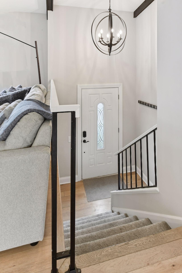 foyer entrance with wood-type flooring and a chandelier