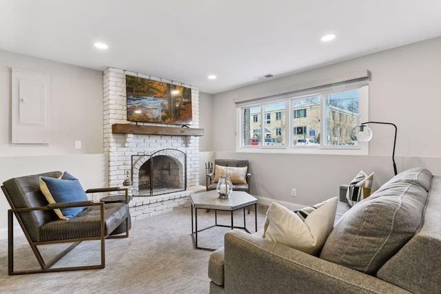 carpeted living room featuring electric panel and a brick fireplace