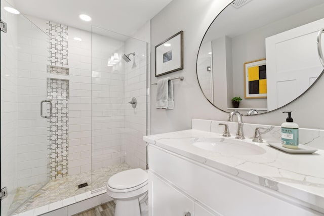 bathroom featuring hardwood / wood-style floors, vanity, an enclosed shower, and toilet