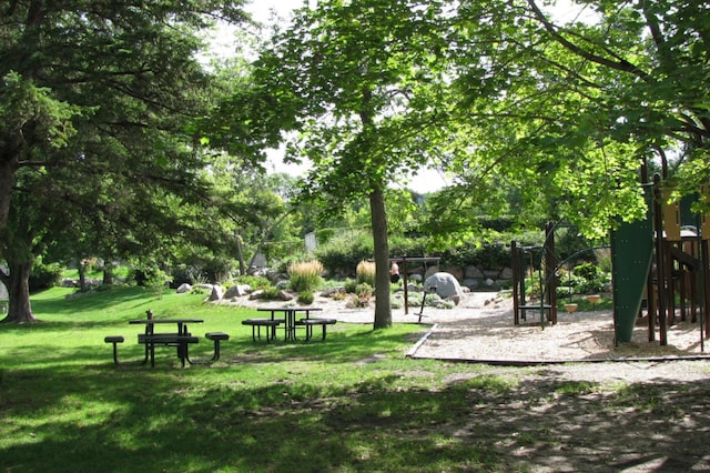 view of property's community featuring a lawn and playground community