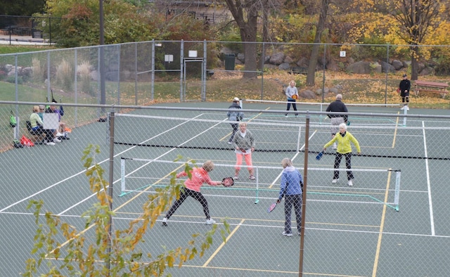 view of tennis court featuring fence