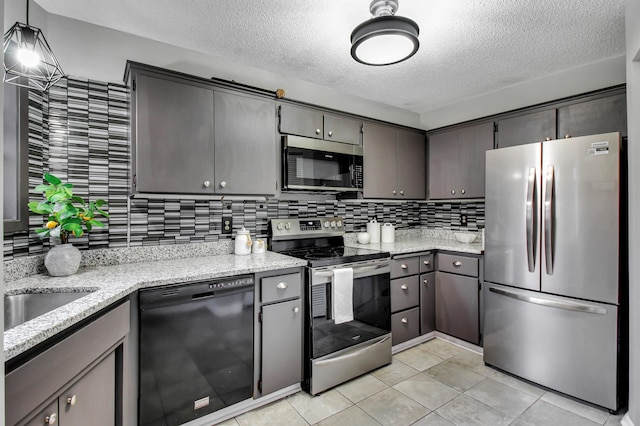 kitchen featuring tasteful backsplash, stainless steel appliances, a textured ceiling, and light tile patterned flooring